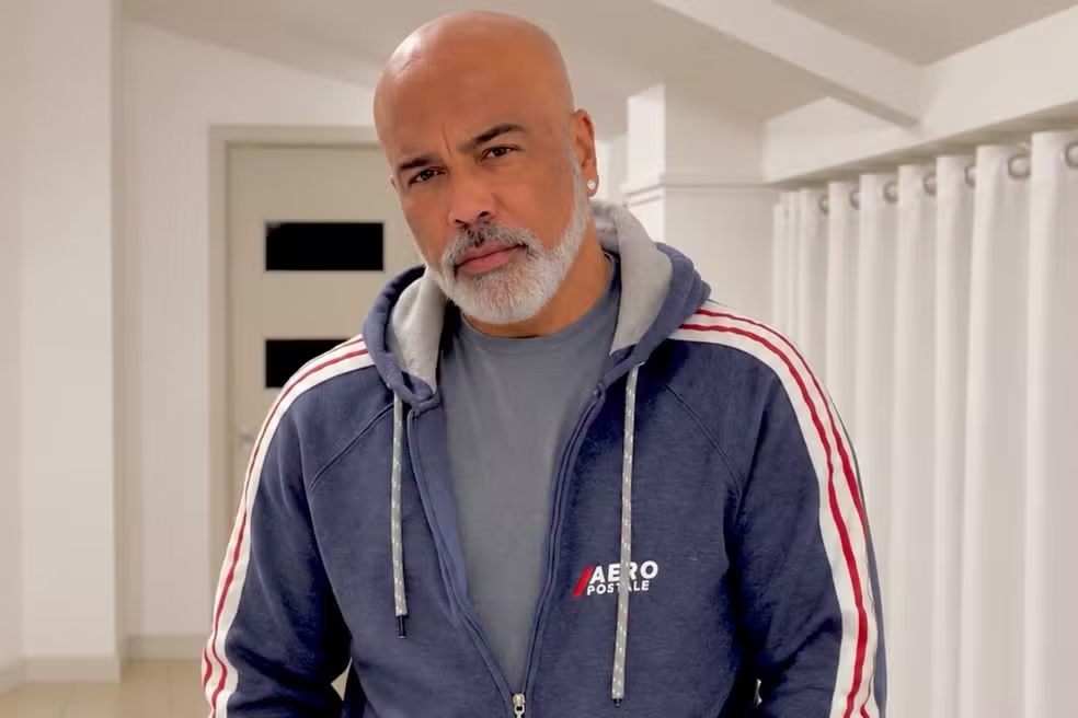 Cantor Rick, da dupla com ]rick e Renner. Ele está usando uma jaqueta azul. Por dentro uma camisa cinza.