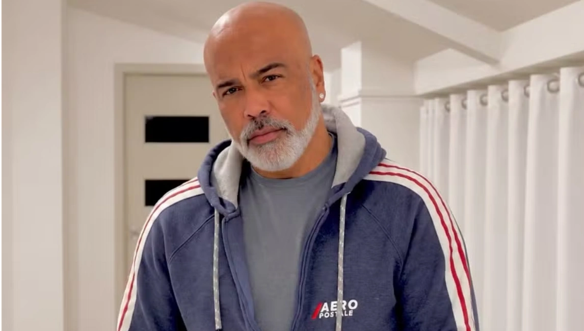 Cantor Rick, da dupla com ]rick e Renner. Ele está usando uma jaqueta azul. Por dentro uma camisa cinza.